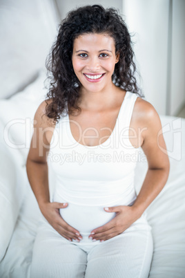 Portrait of pregnant woman touching her tummy