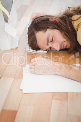 Tired hipster resting head on computer keyboard