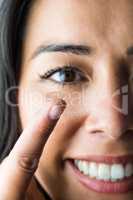 Smiling woman with a contact lens