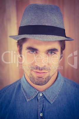 Close-up portrait of confident hipster wearing hat