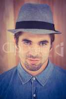 Close-up portrait of confident hipster wearing hat