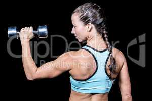 Rear view of woman lifting dumbbell