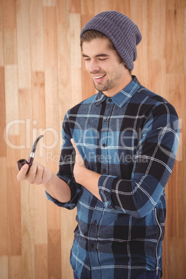 Happy hipster holding smoking pipe