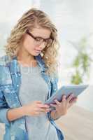 Woman wearing eyeglasses while using digital tablet