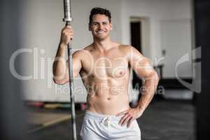 Muscular smiling man holding barbell