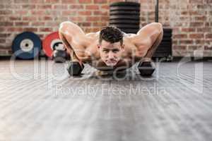 Portrait of man doing dumbbell push ups