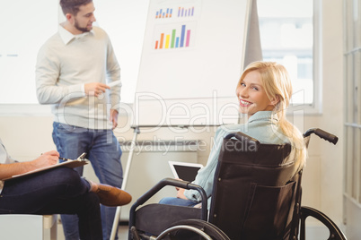Disabled businesswoman on wheelchair holding digital tablet