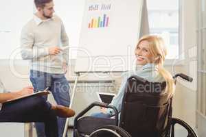 Disabled businesswoman on wheelchair holding digital tablet