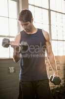 Man lifting dumbbell while looking down