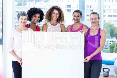 Portrait of smiling women holding board