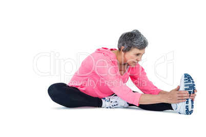 Mature woman touching toes while exercising