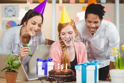 Businesswoman celebrating birthday with colleagues