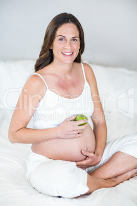 Portrait of pregnant woman with Granny Smith apple