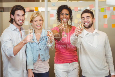 Happy colleagues holding champagne flute in party