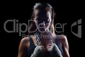 Portrait of female boxer holding chain around neck