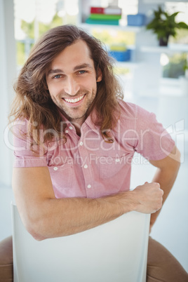 Portrait of happy hipster sitting on chair