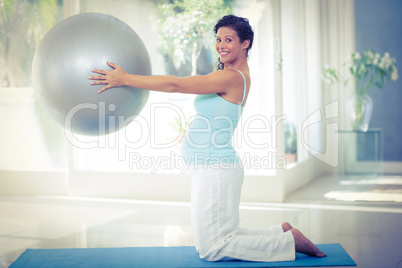 Portrait of pregnant woman holding exercise ball