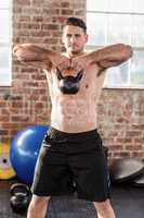 Muscular man lifting a kettlebell