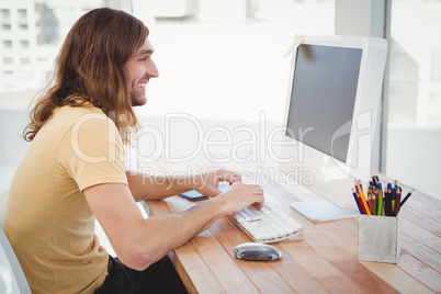 Happy hipster working at computer desk