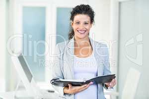 Smiling beautiful businesswoman holding document