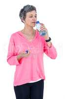 Mature woman drinking water while listening music