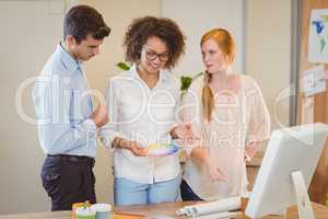 Smiling business people standing by desk