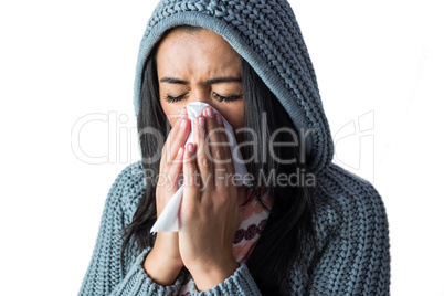 Woman sneezing into her tissue