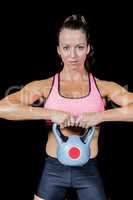 Portrait of confident woman lifting kettlebell
