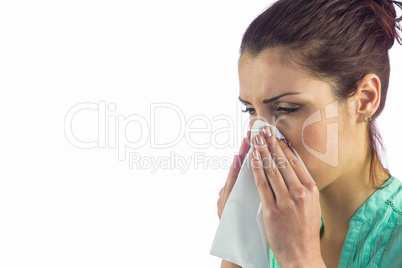 Close-up of sneezing woman with tissue on mouth