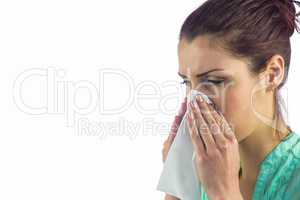 Close-up of sneezing woman with tissue on mouth