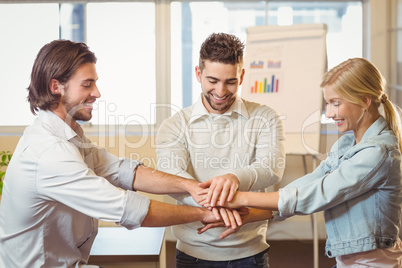 Smiling business people with hand stacked in meeting room