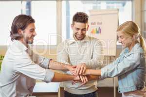 Smiling business people with hand stacked in meeting room