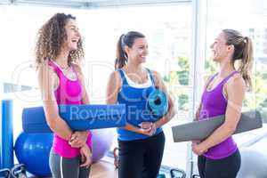 Women smiling while looking at each other in fitness studio