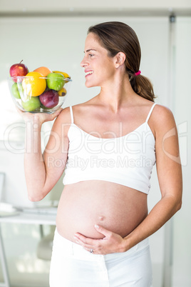 Happy woman with fruit bowl