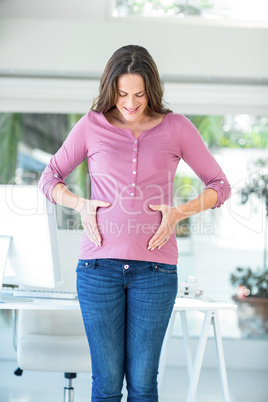 Happy woman touching pregnant belly