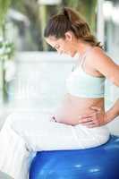 Happy woman sitting on exercising ball