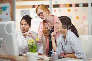 Businesswoman showing something to colleagues on computer