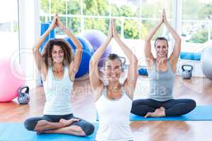 Happy woman doing lotus pose with hands joined overhead