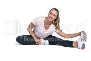 Cheerful woman touching toes while exercising