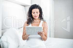 Beautiful pregnant woman using digital tablet