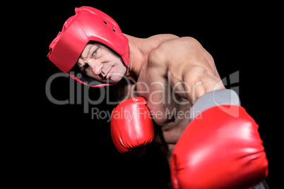 Portrait of boxer with gloves punching against black background