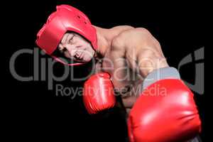 Portrait of boxer with gloves punching against black background