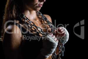 Midsection of female athlete holding chain