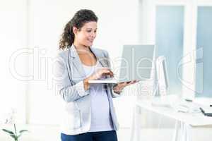 Pregnant businesswoman using laptop