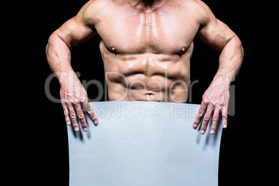 Midsection of muscular man holding white blank paper