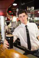 Portrait of male bartender serving beer