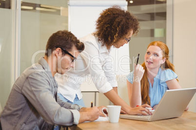 Business people discussing using laptop