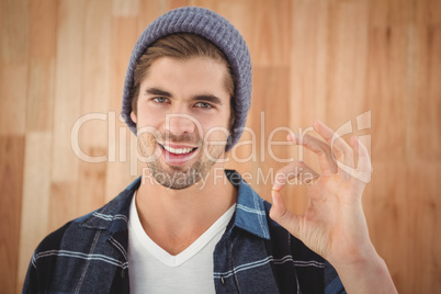 Portrait of happy hipster showing OK sign
