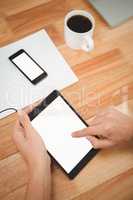 Man using digital tablet with smartphone and coffee on table