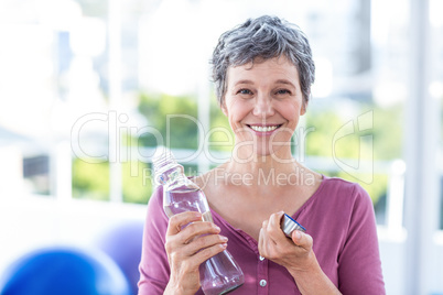 Portrait of happy mature woman with water bottle